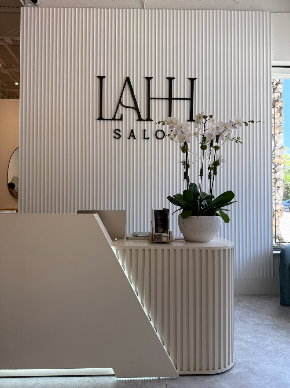 Salon reception area with 'LAHH SALON' sign and decorative elements.