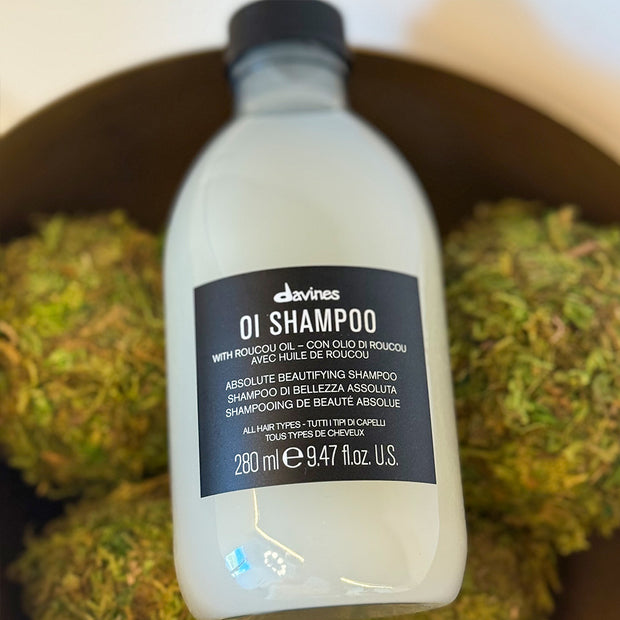 Davines shampoo bottle with label on a green textured background