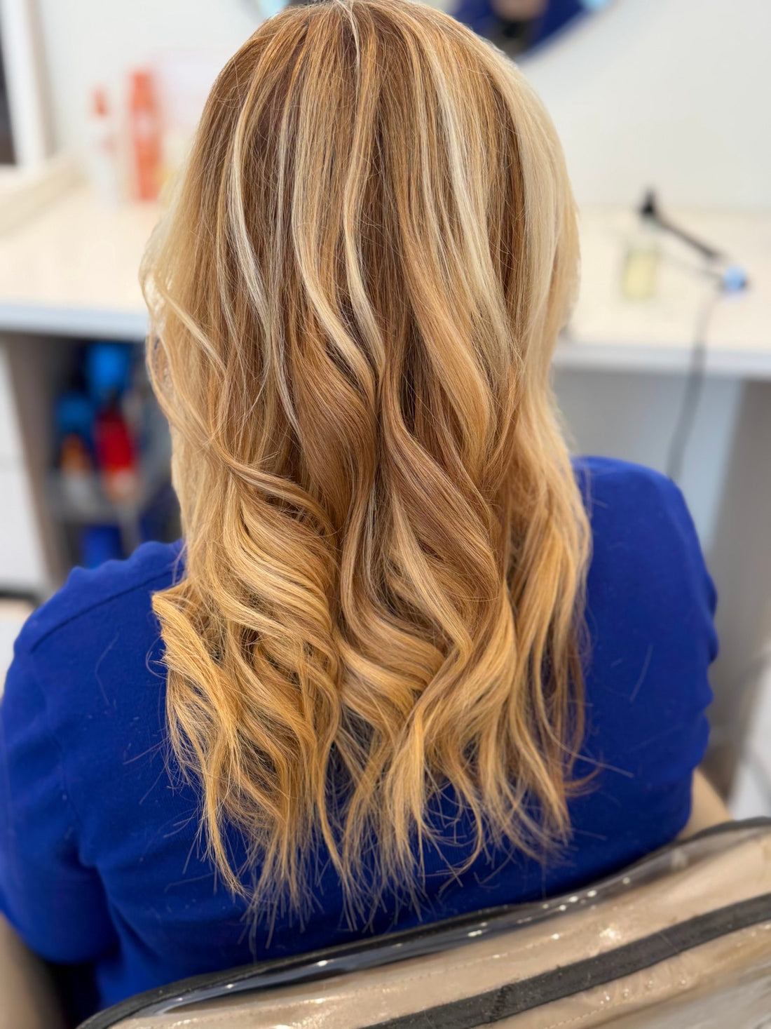Dimensional blonde hair extensions styled in loose curls at LAHH Salon